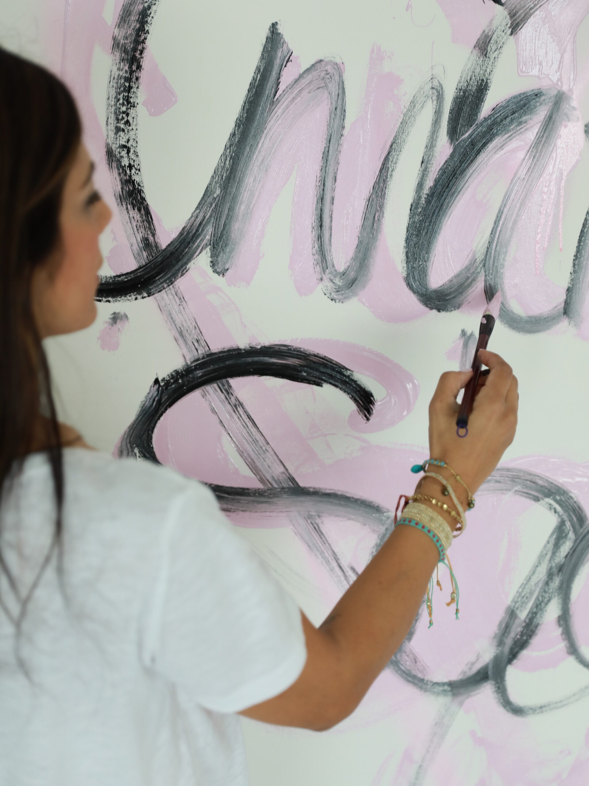 Maria Saad painting a pink and black canvas in her studio