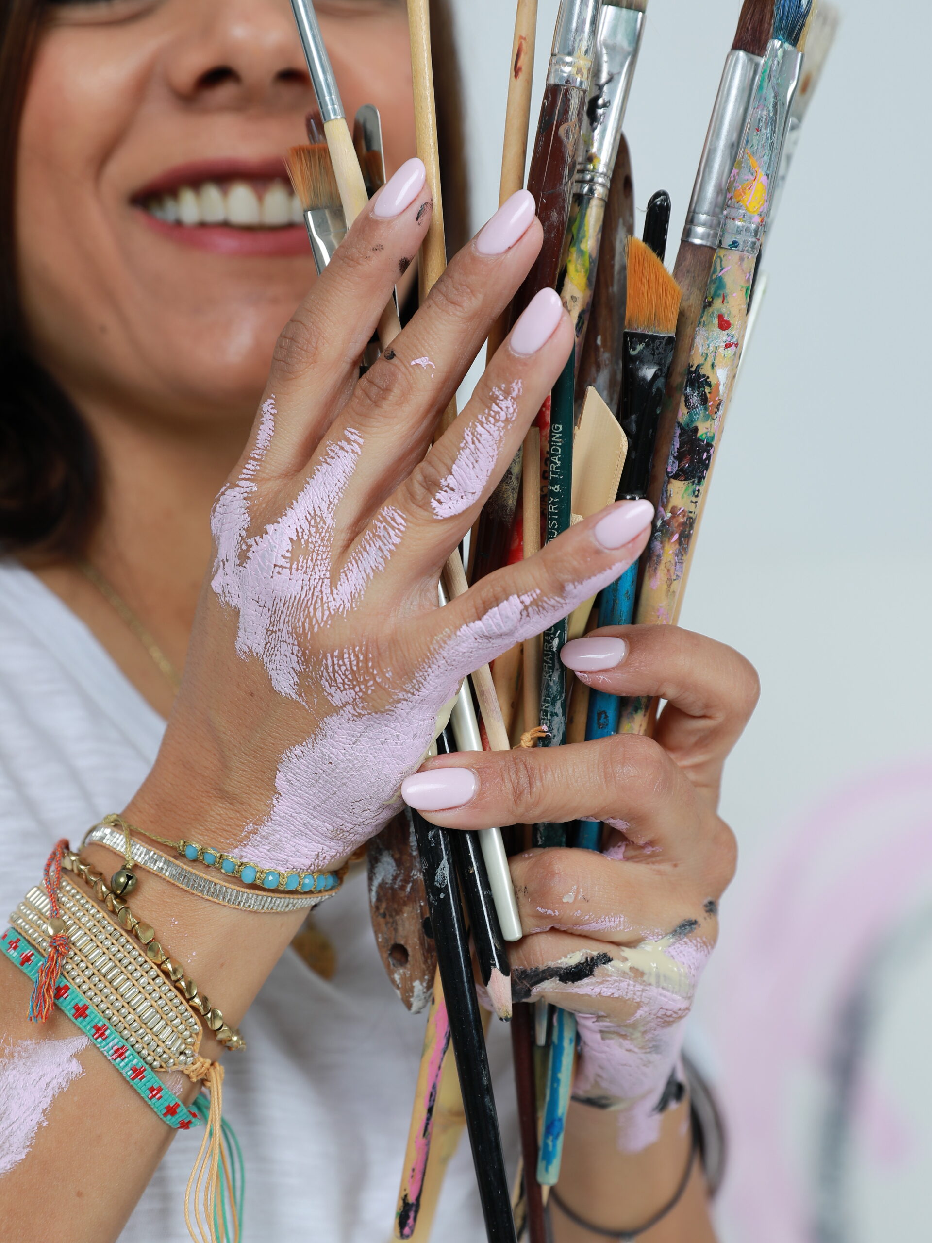 Close-up of artist hands holding paintbrushes coated with pigment