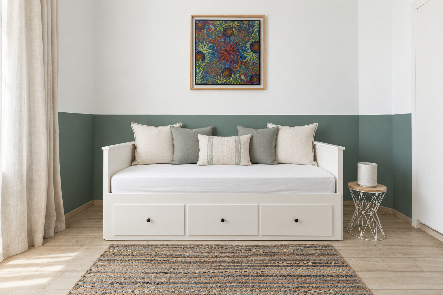 Green-toned bedroom interior featuring an elegant daybed, curated framed artwork, woven rug, drapery, and side table